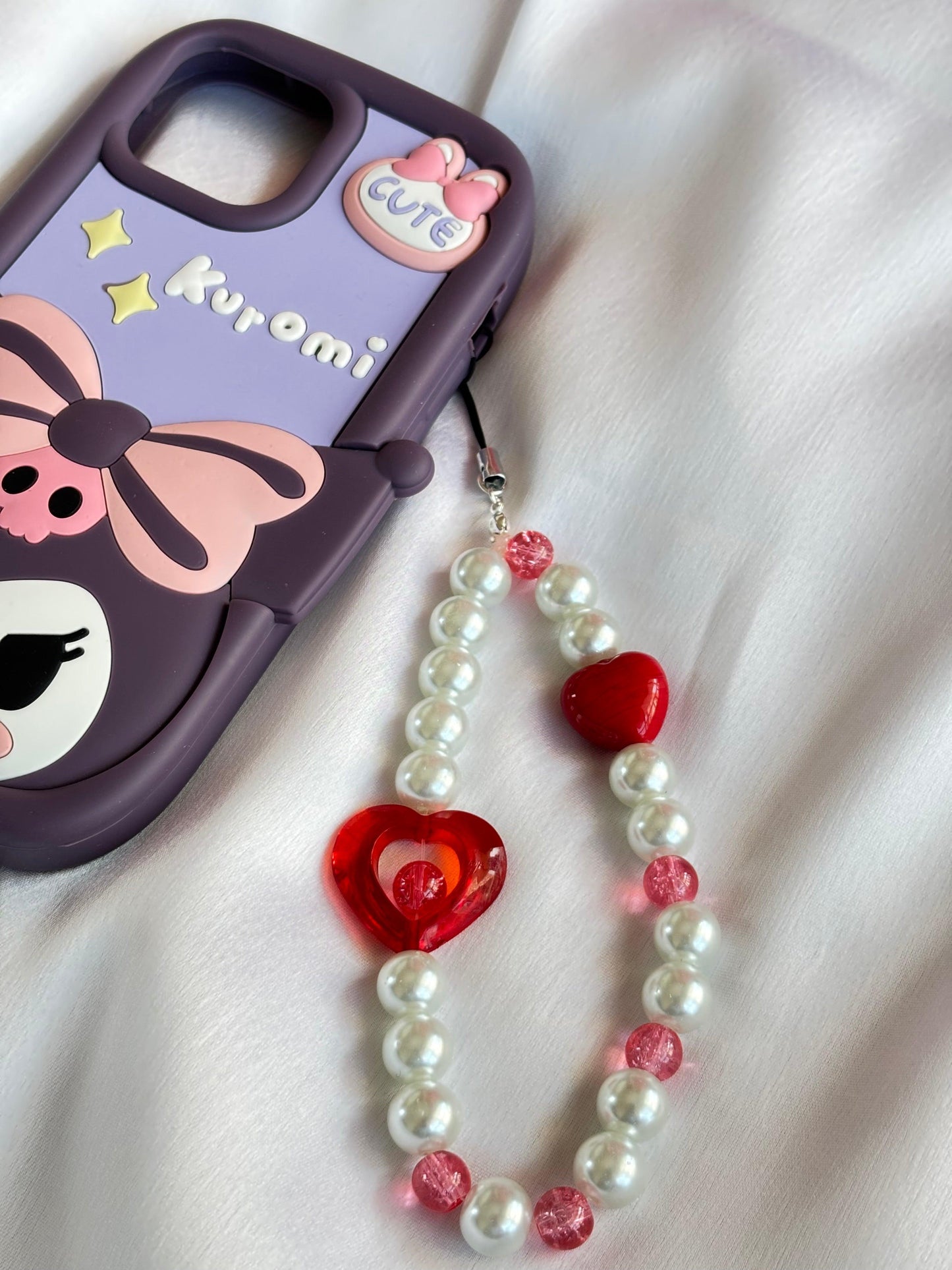 Ruby Love Mobile Charm featuring red heart beads and pearl accents, styled with a cute Kuromi phone case.