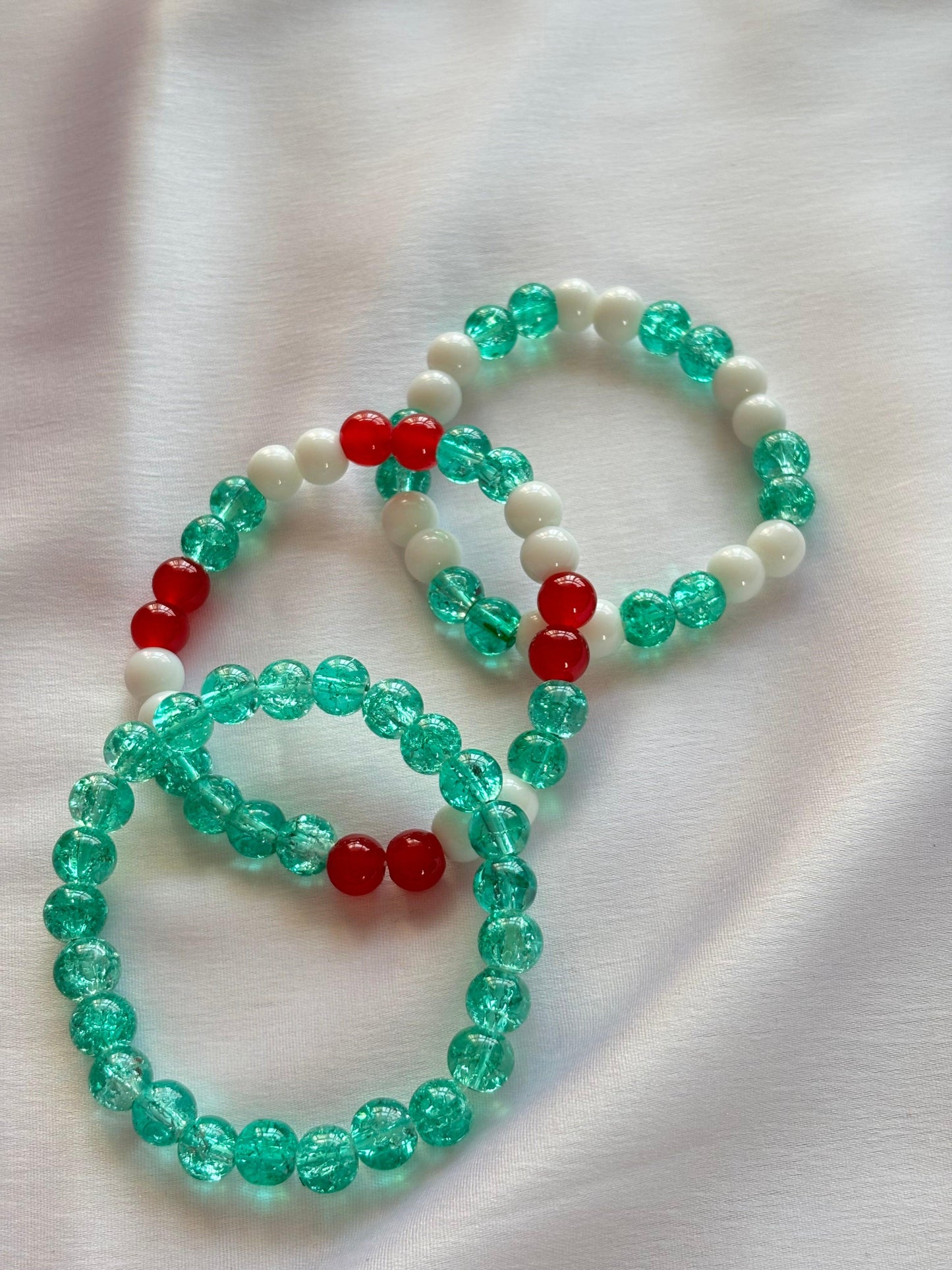 Festive holiday bracelet set featuring vibrant red, green, and white beads, perfect for seasonal celebrations.